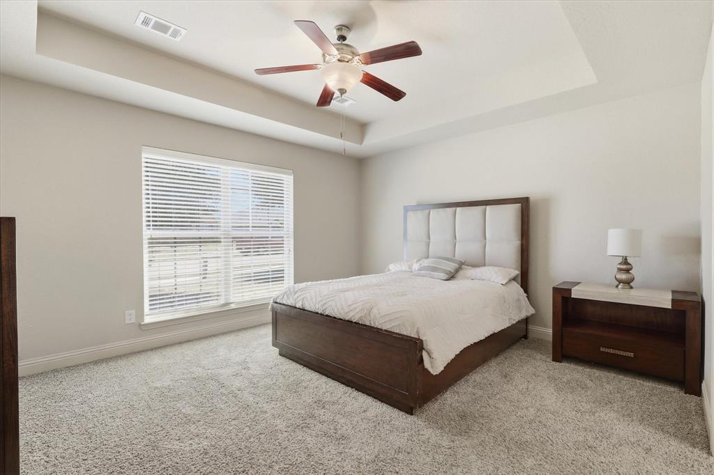 115 Blue Quail Road Red Oak, TX 75154 - Photo 4 of 35 Tray ceiling with a ceiling fan, large window with blinds, and light-colored carpeting
