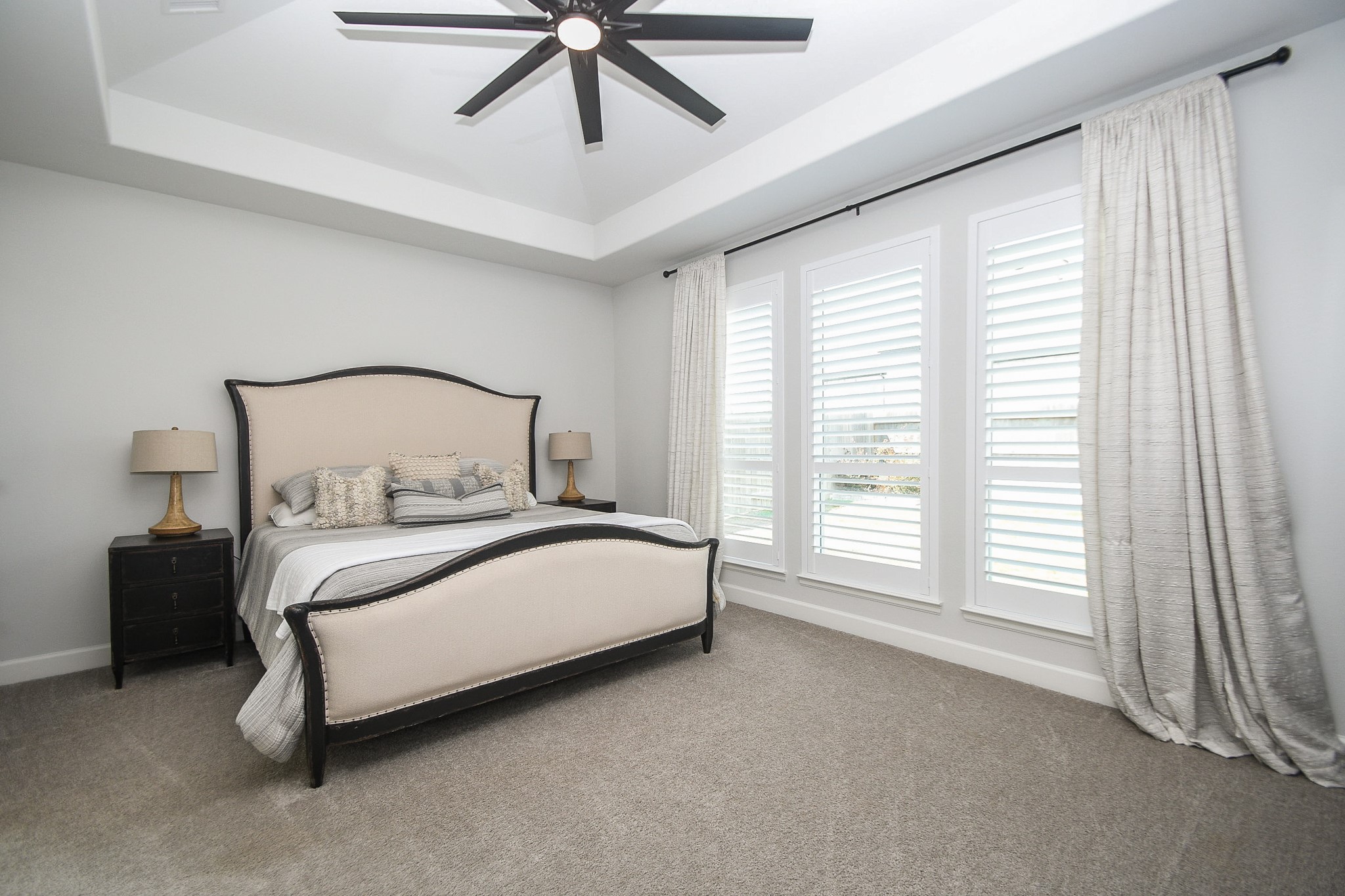 30314 Brook Point Fulshear, TX 77441 - Photo 13 of 38 Primary bedroom has tray ceiling, oversized ceiling fan, and custom shutters