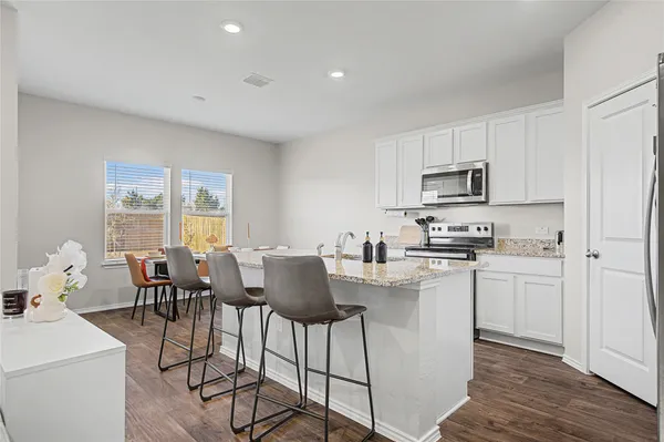 a kitchen with appliances cabinets and wooden floor