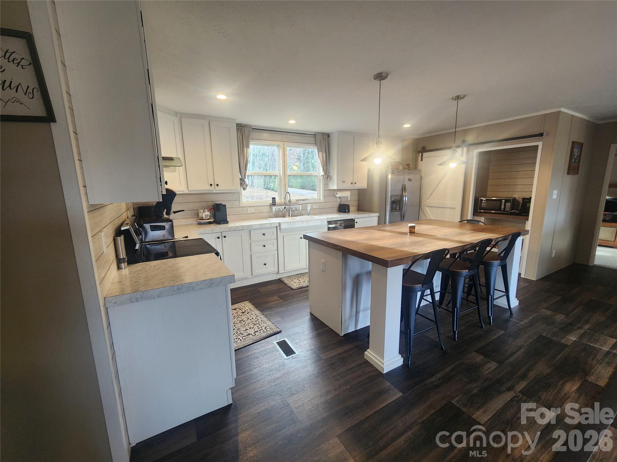 659 Cold Creek Road Canton, NC 28716 - Photo 28 of 37 a kitchen with a stove a refrigerator a sink dishwasher with a dining table and chairs