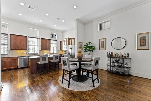 a living room with furniture kitchen view and a wooden floor