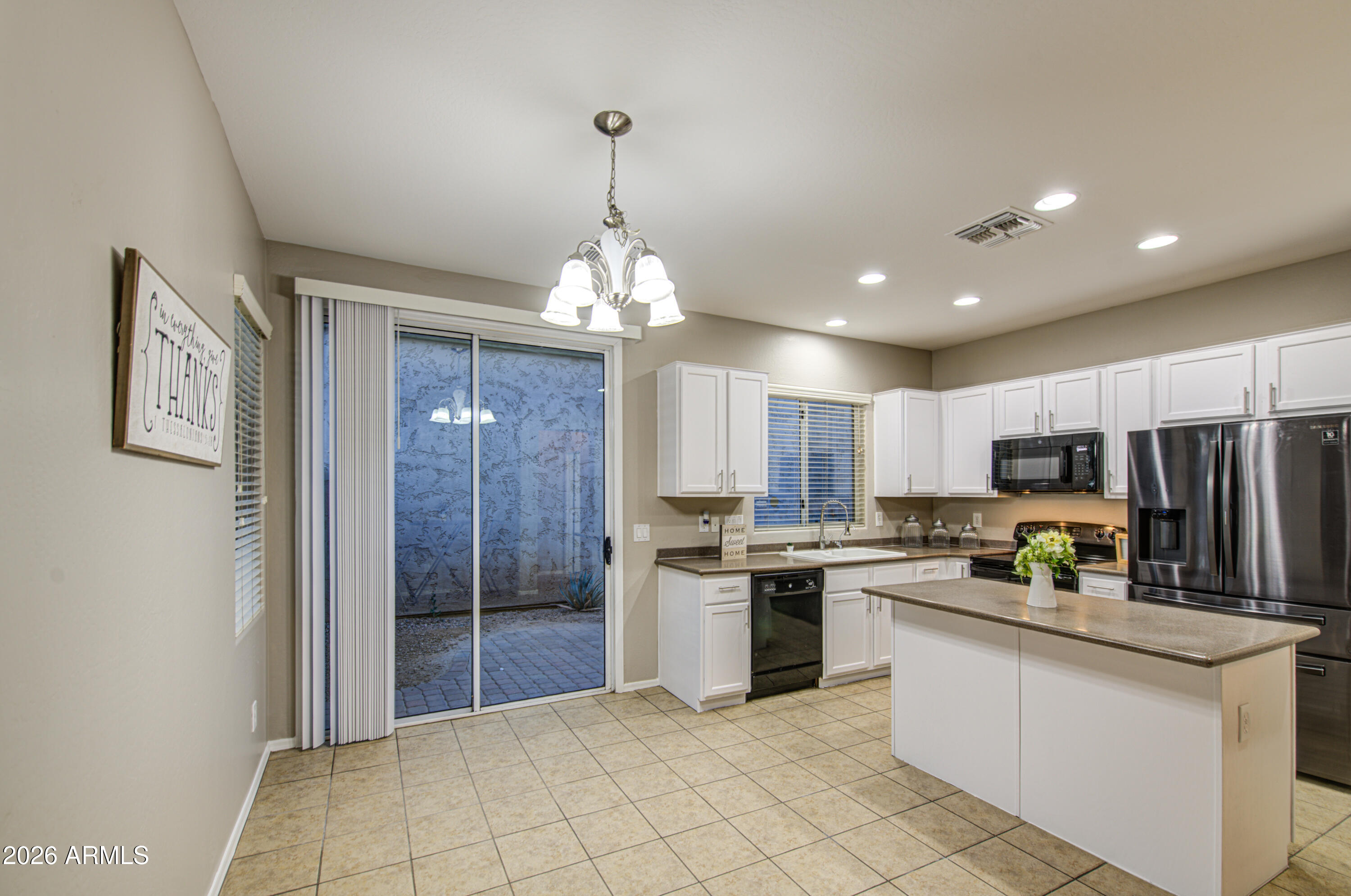 7759 West Monte Vista Road Phoenix, AZ 85035 - Photo 12 of 43 a kitchen with stainless steel appliances a refrigerator sink and microwave