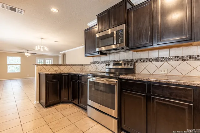a kitchen with granite countertop stainless steel appliances a refrigerator and a sink