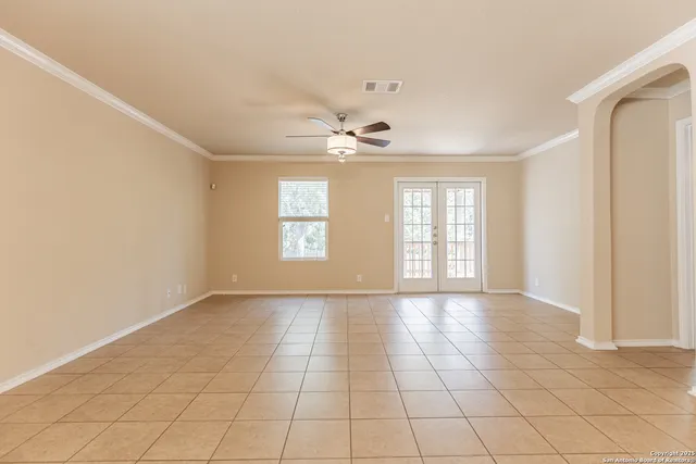 an empty room with windows and fan