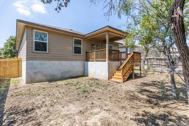 a view of a house with a wooden deck and a backyard