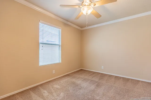 an empty room with a chandelier fan and closet area