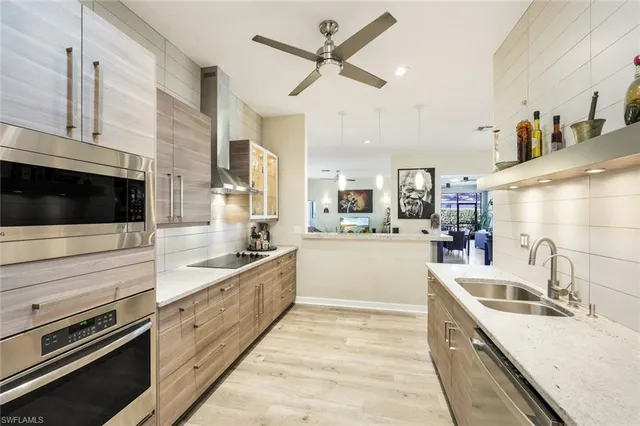 a large kitchen with stainless steel appliances kitchen island granite countertop a sink and cabinets