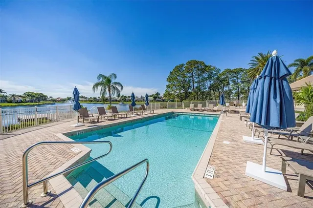 a view of a swimming pool with a lounge chair and floor to ceiling window