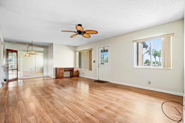 a view of an empty room with window and wooden floor