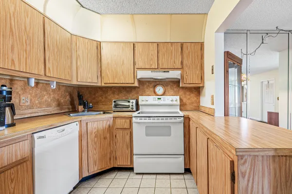 a kitchen with cabinets appliances a sink and a counter top space