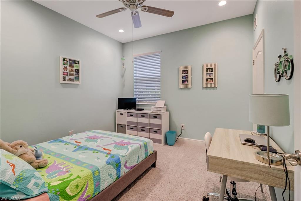 6959 Avalon Circle, Unit 1704 Naples, FL 34112 - Photo 13 of 25 a bedroom with a bed and a desk