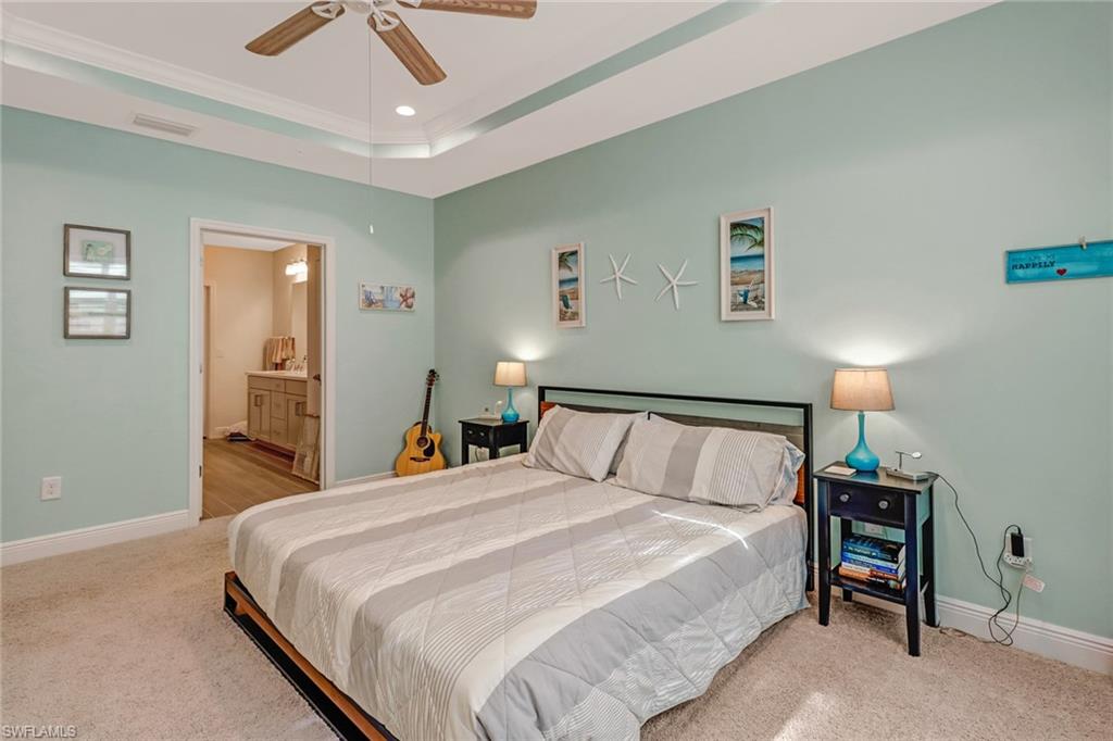 6959 Avalon Circle, Unit 1704 Naples, FL 34112 - Photo 17 of 25 a bedroom with a bed and a lamp on a dresser