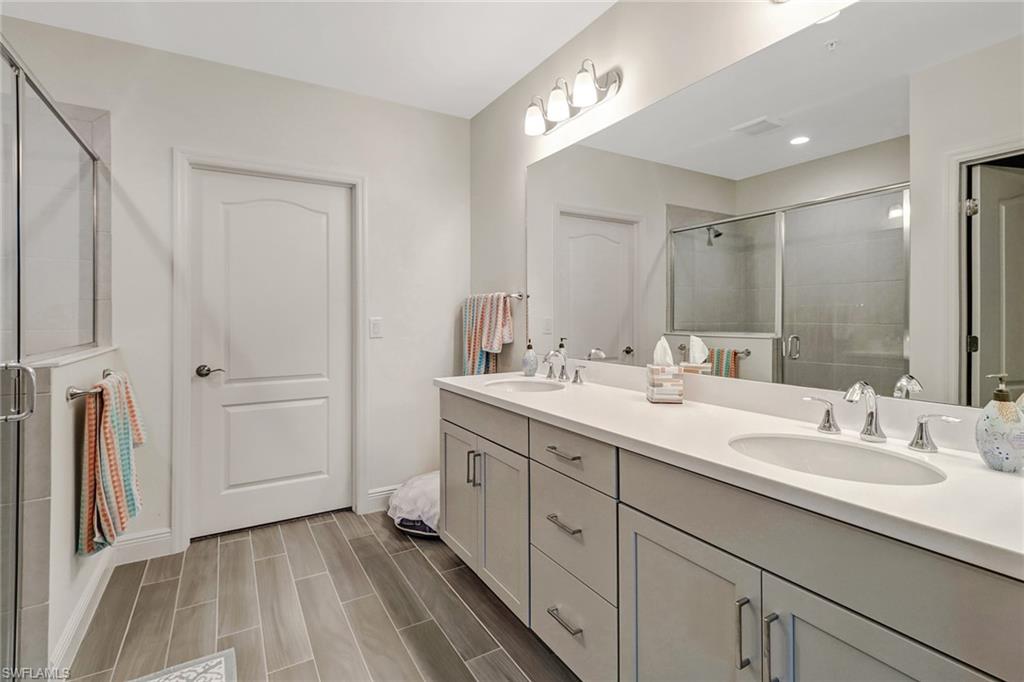 6959 Avalon Circle, Unit 1704 Naples, FL 34112 - Photo 18 of 25 a bathroom with a double vanity sink and mirror