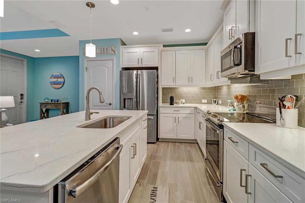 6959 Avalon Circle, Unit 1704 Naples, FL 34112 - Photo 4 of 25 a kitchen with a sink stainless steel appliances and white cabinets