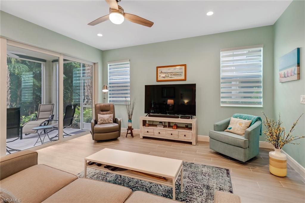 6959 Avalon Circle, Unit 1704 Naples, FL 34112 - Photo 8 of 25 a living room with furniture and a flat screen tv