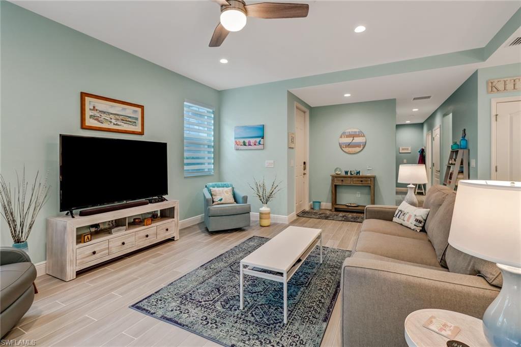 6959 Avalon Circle, Unit 1704 Naples, FL 34112 - Photo 9 of 25 a living room with furniture and a flat screen tv