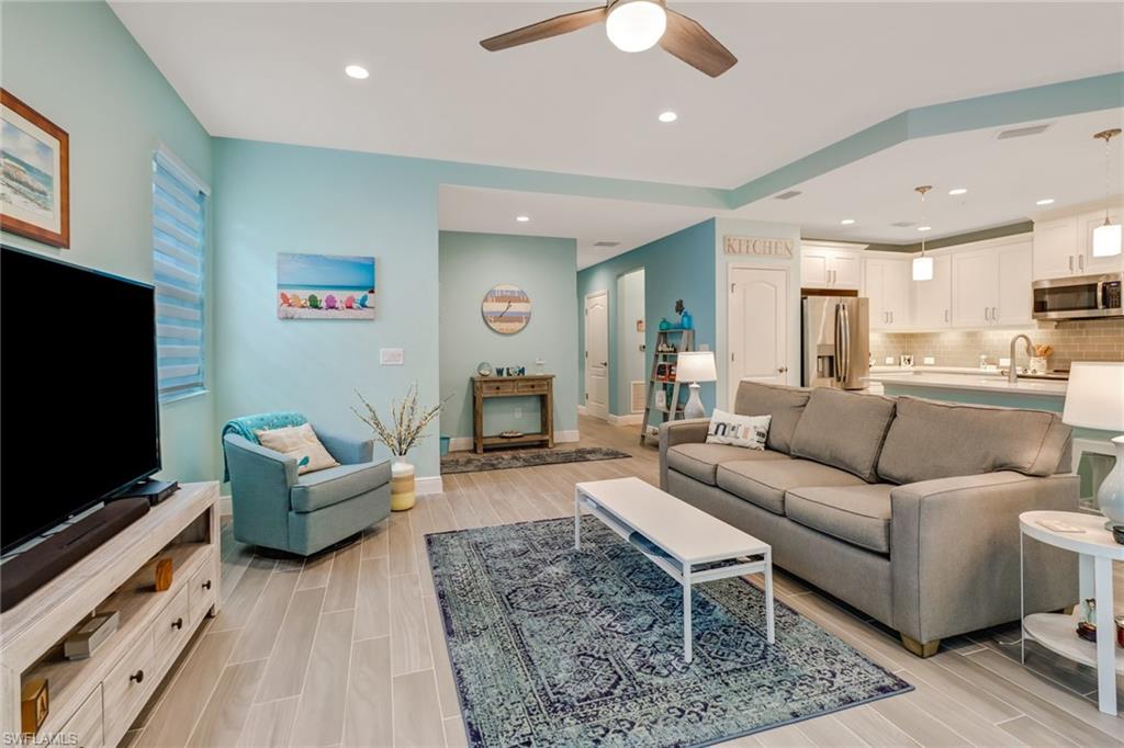 6959 Avalon Circle, Unit 1704 Naples, FL 34112 - Photo 10 of 25 a living room with furniture and a flat screen tv