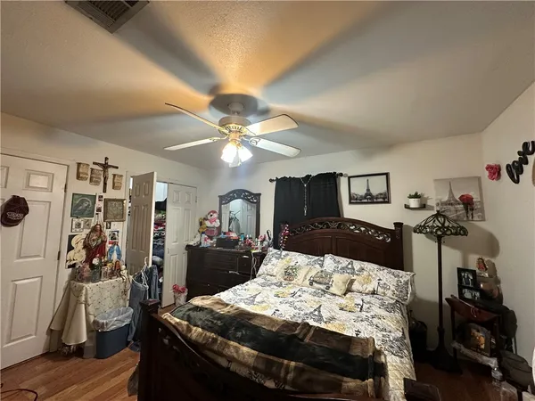 a bedroom with a bed and wooden floor
