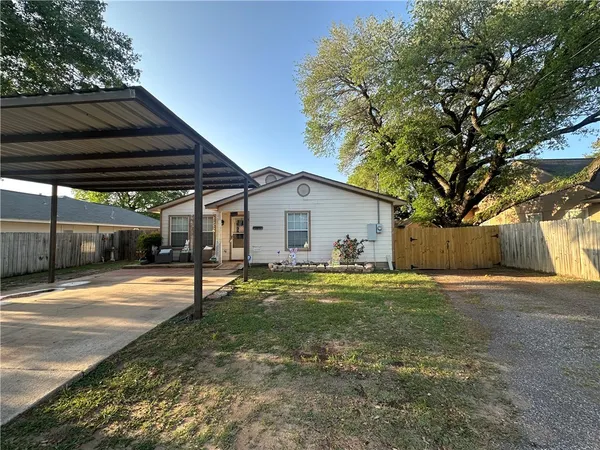 a view of a house with backyard and a tree