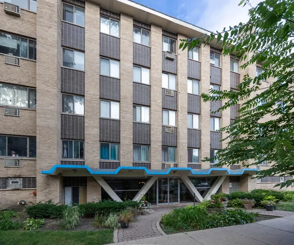 a front view of a building with glass windows and yard
