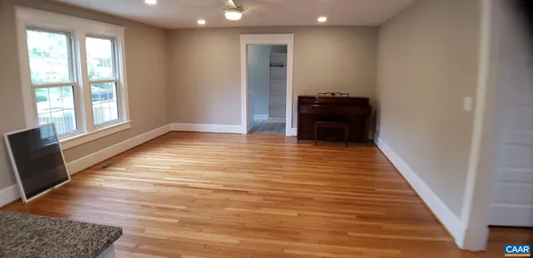 a view of a hallway with wooden floor and a rug