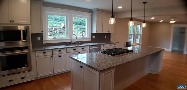 a kitchen with kitchen island a sink stove and microwave