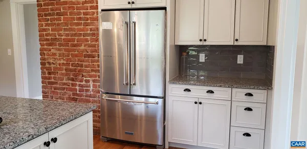 a kitchen with granite countertop white cabinets and stainless steel appliances