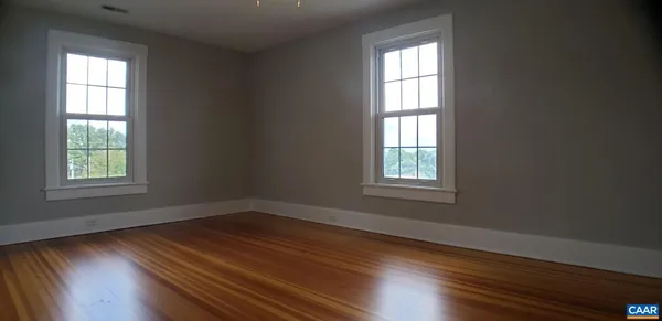 an empty room with wooden floor and a window