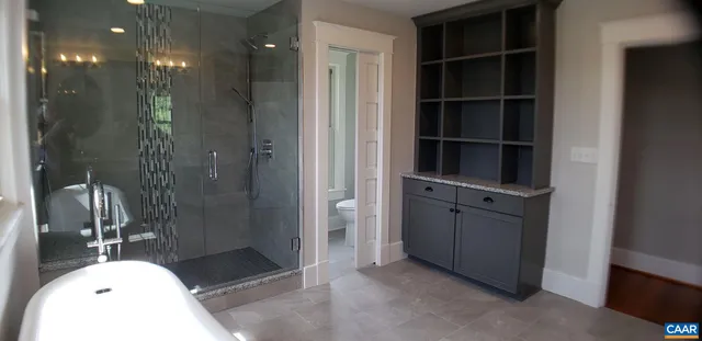 a bathroom with a granite countertop shower and a sink