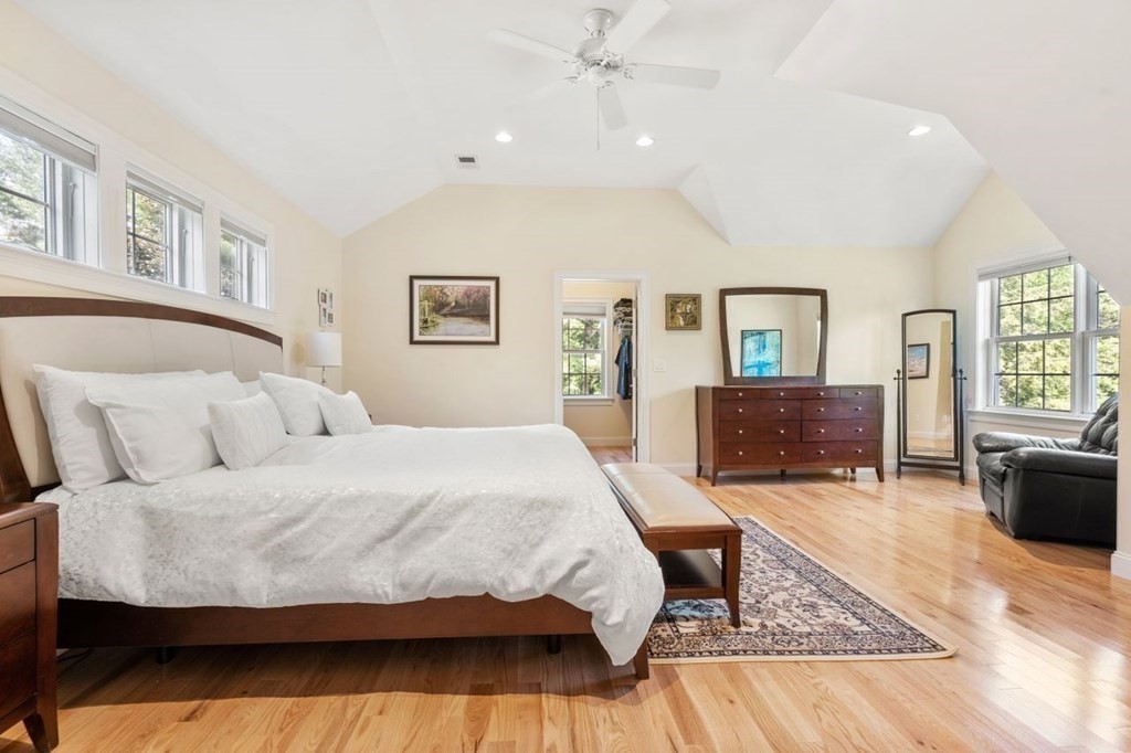1 Hawes Road Sudbury, MA 01776 - Photo 19 of 38 a bedroom with a large bed a chandelier and windows