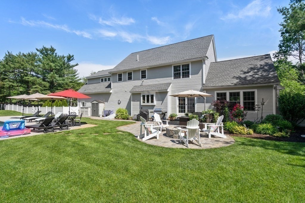 1 Hawes Road Sudbury, MA 01776 - Photo 35 of 38 a patio with a table and chairs under an umbrella