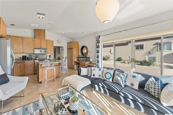 a living room filled with furniture kitchen view and a large window