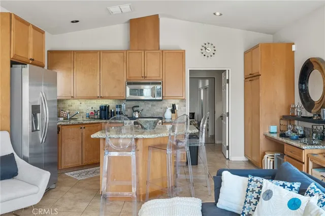 a kitchen with stainless steel appliances granite countertop a refrigerator a stove top oven a sink and dishwasher