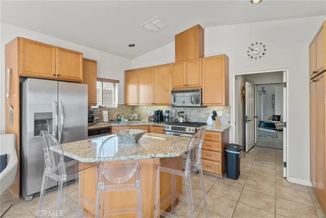 a kitchen with stainless steel appliances granite countertop a sink a stove and refrigerator