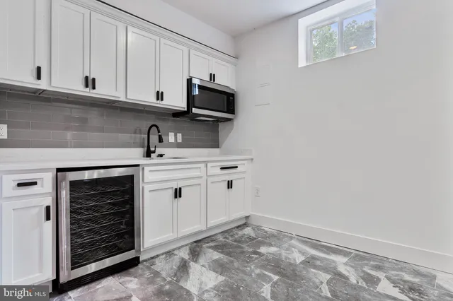 a kitchen with white cabinets and white appliances