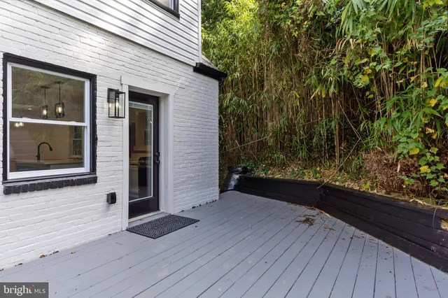 a view of backyard with hardwood floor and brick wall
