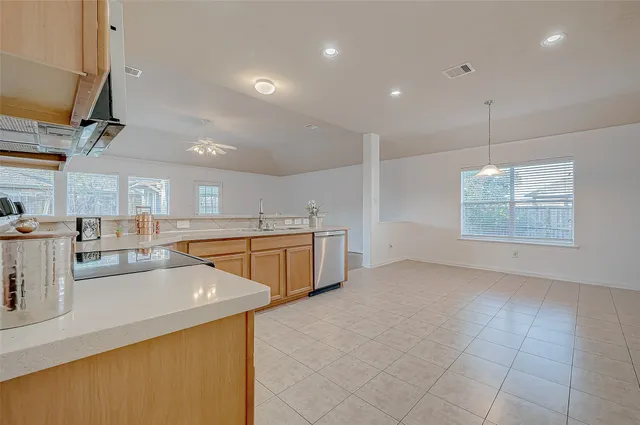 a kitchen with granite countertop a stove top oven a sink dishwasher and a refrigerator with wooden floor