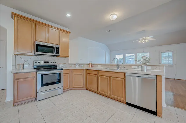 a large kitchen with granite countertop a sink a counter top space and cabinets