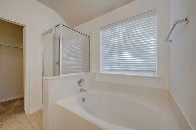 a bathroom with a tub sink and mirror