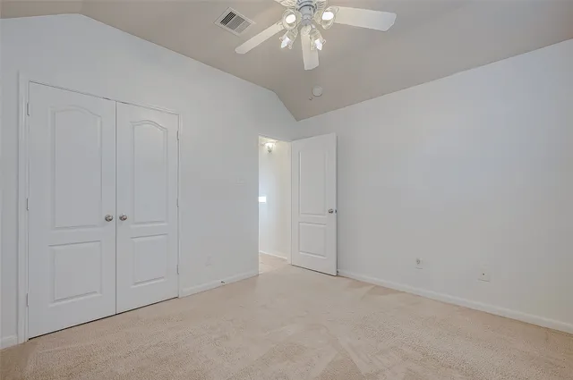 en empty room with windows and ceiling fan