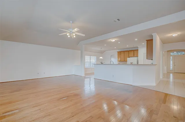 a view of an empty room and kitchen view