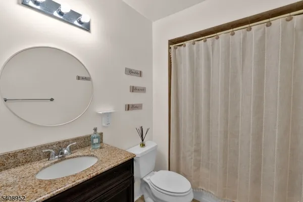 a bathroom with a granite countertop sink toilet and shower