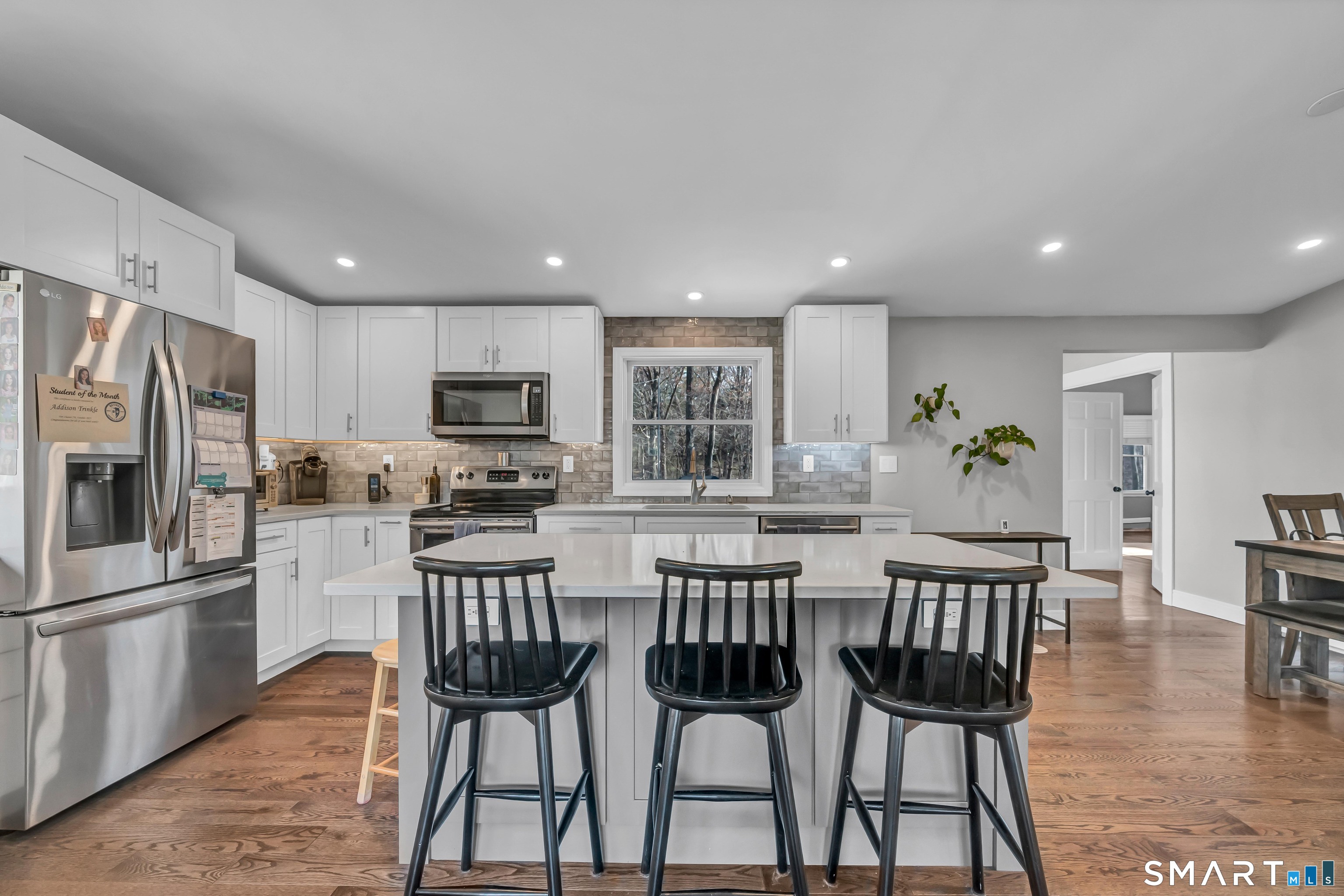 10 Grove Place Bethel, CT 06801 - Photo 6 of 33 a kitchen with stainless steel appliances a dining table chairs refrigerator microwave and cabinets