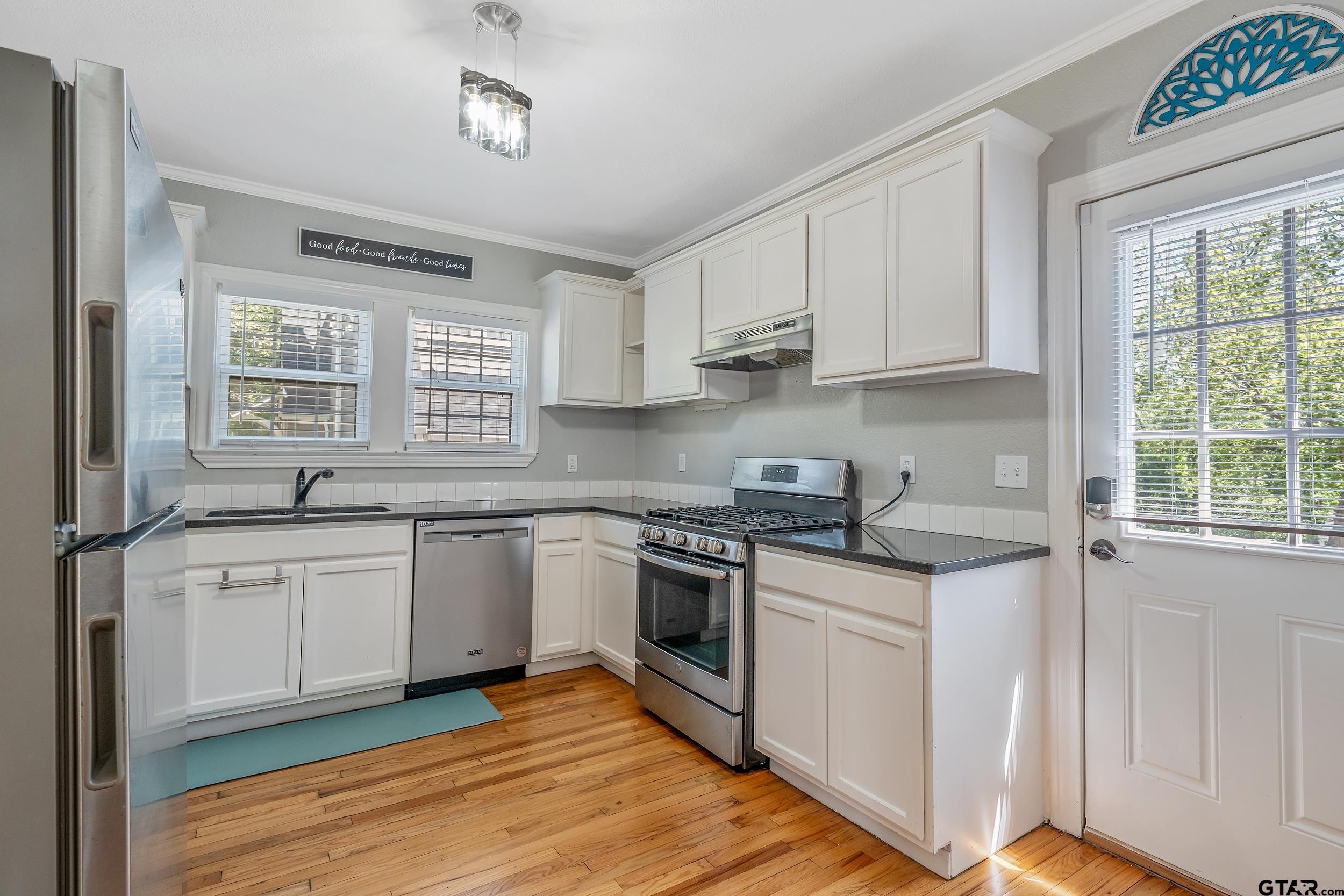 434 South Vine Avenue Tyler, TX 75702 - Photo 8 of 29 a kitchen with stainless steel appliances granite countertop a stove a sink dishwasher and white cabinets with wooden floor