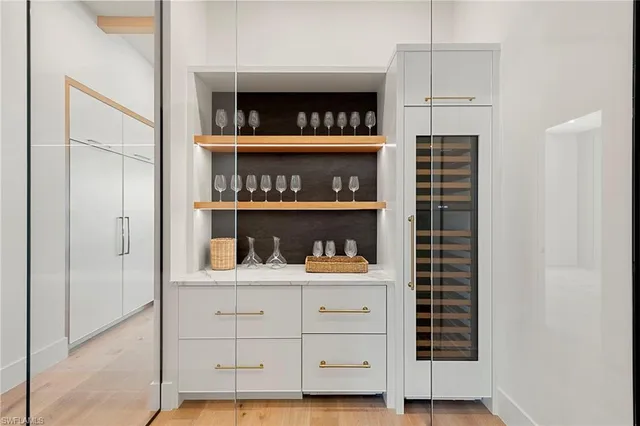 a kitchen with white cabinets and wooden floor
