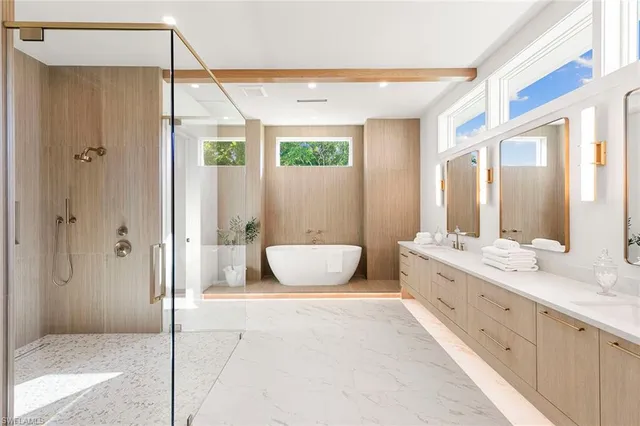 a bathroom with a double vanity sink toilet mirror and bathtub