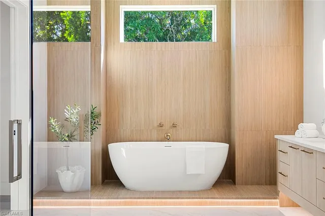 a white tub sitting next to a window