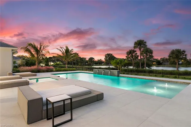 a view of an swimming pool with lawn chairs under an umbrella