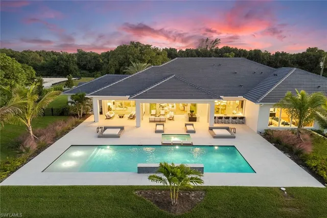 a view of an empty room with wooden floor and windows