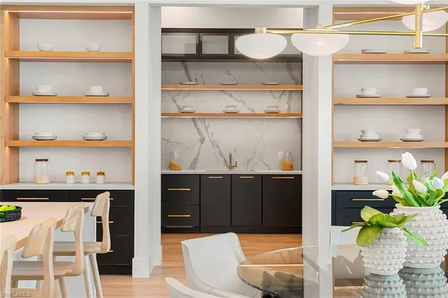 a living room with white cabinets and a wooden floor
